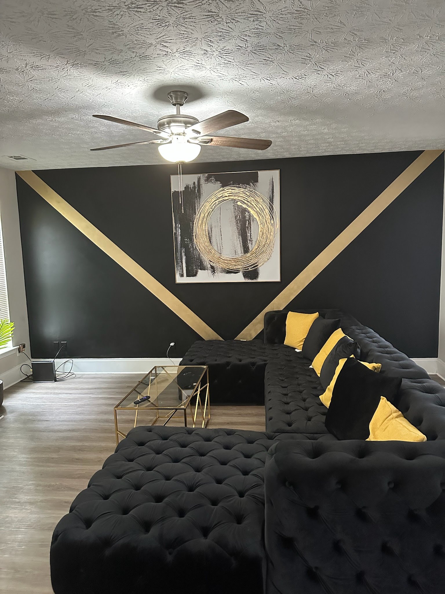 Black and gold living room with sectional seating