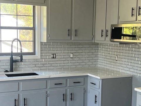 Gray kitchen cabinets and tile backsplash
