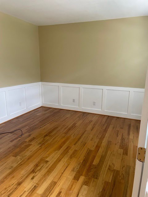 Room with hardwood floor and white wall trim