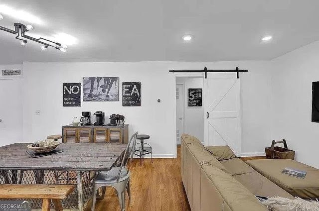 Open living room with white walls and barn door